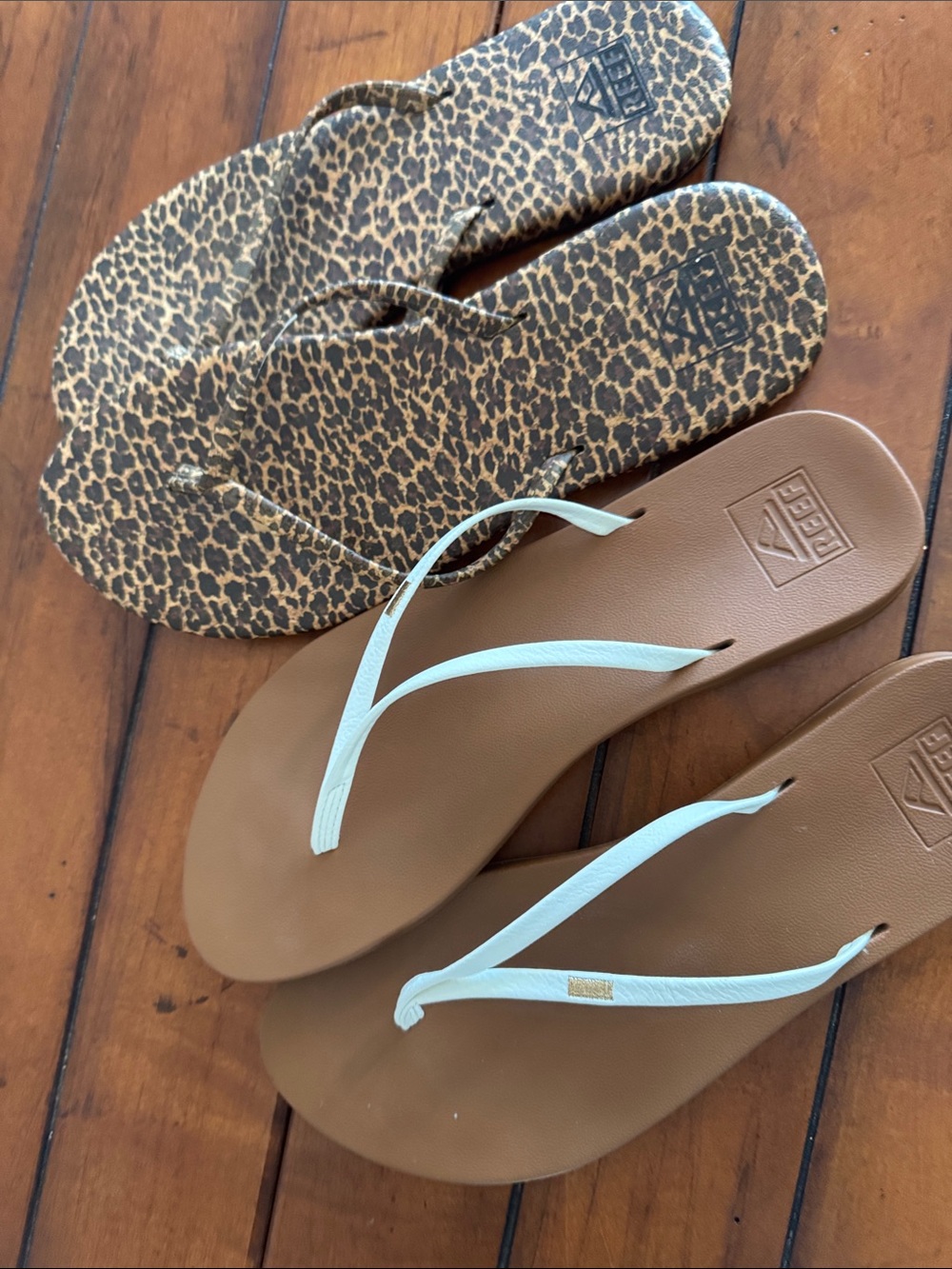 2 pair Reef Women’s Flip Flops - one with White Straps and one Leopard